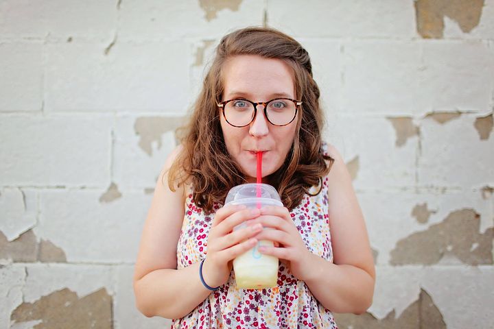 woman wearing prescription glasses wile drinking a frappe
