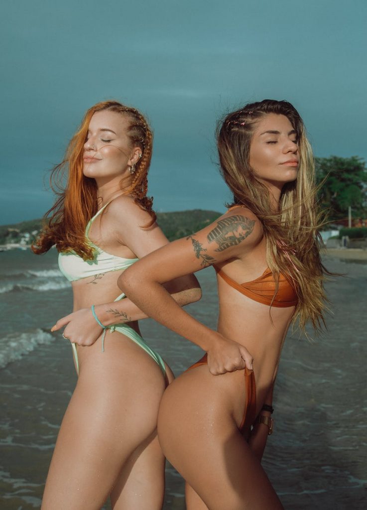 Two women flexing their designer bathing suits
